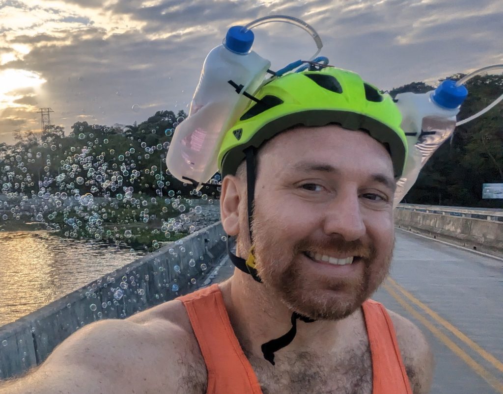 Dr Andy Quitmeyer producing bubbles as he rides a bicycle